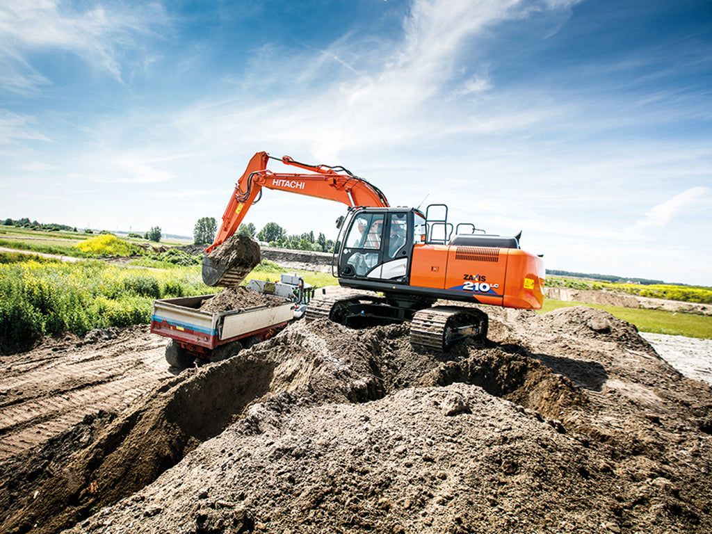 Hitachi excavator loading dirt into a dump truck