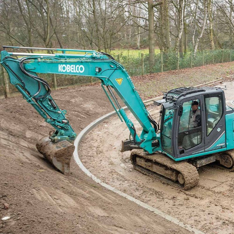 Kobelco excavator grading curved dirt slope